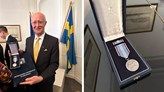 Johan Schnürer håller i utmärkelsen och en närbild på medaljen.