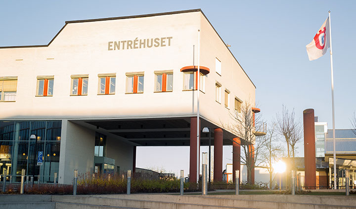 Entréhuset med en flaggstång bredvid.